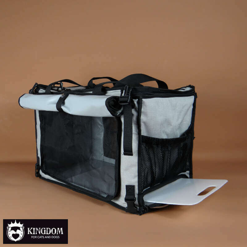 Zijkant van de Mobiele verzorgings-tas met opgerold voorpaneel en zicht op de uitschuifbare verzorgingsplaat.